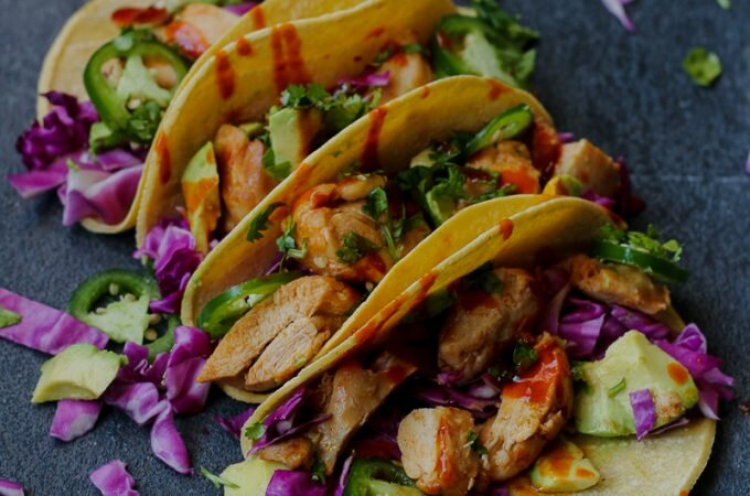 Easy Korean chicken tacos with a red cabbage, avocado, and jalapeño slaw. Quick to make, perfect for meal prep, or a weeknight meal!